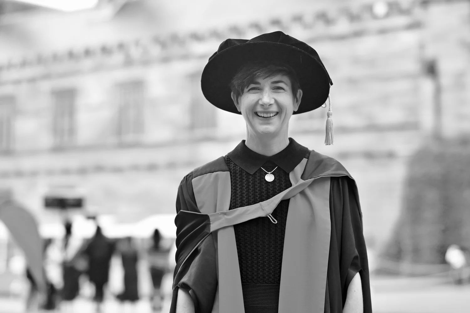 Poppie Johnson smiling in graduation robes and cap.